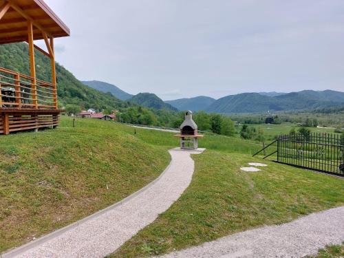 a walkway in a field with mountains in the background at Apartments Denis in Tolmin