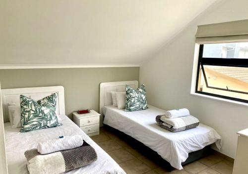 a bedroom with two beds and a window at Fischreiher Self-Catering Condo in Swakopmund