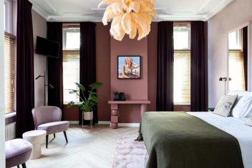 a bedroom with a bed and a chandelier at Boutique B&B Villa van Voss in Etten-Leur