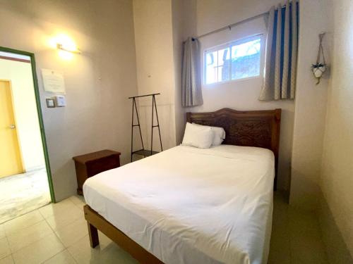 1 dormitorio con 1 cama blanca y ventana en Hostal Zócalo, en Mérida