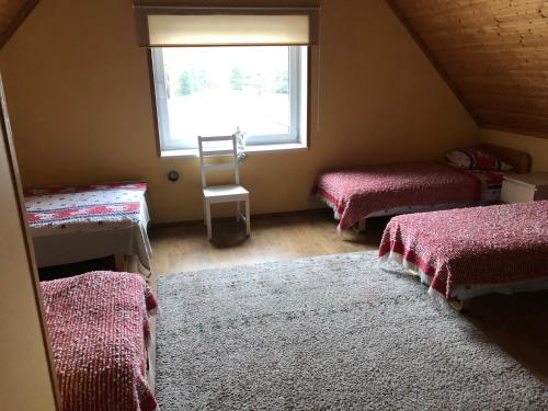 um quarto no sótão com 2 camas e uma janela em Oraveski talu em Lodja