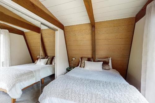 two beds in a room with wooden walls at Sunshine in Sunriver in Sunriver