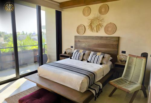 ein Schlafzimmer mit einem großen Bett und einem Stuhl in der Unterkunft Penthouse Privado en Tulum in Tulum