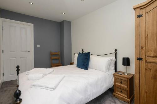 sypialnia z dużym białym łóżkiem z niebieską poduszką w obiekcie A hidden gem in the city, open Luxe 1bed Apt w Nottingham