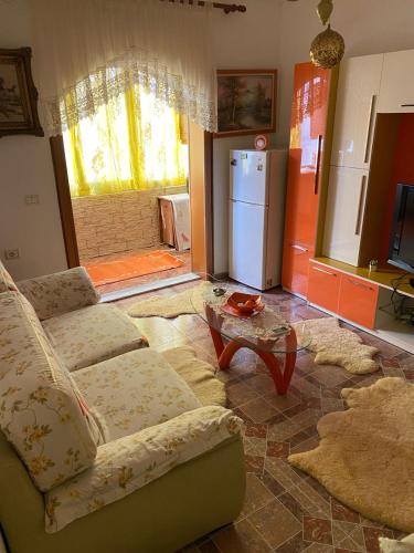 uma sala de estar com um sofá, uma mesa e um frigorífico em Castle Berat em Berat