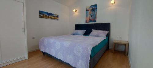 una camera con un letto e un piumone blu e bianco di Apartments Ema & Sea with free private parking a Pola (Pula)
