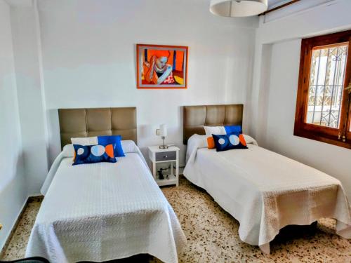 een slaapkamer met twee bedden en een schilderij aan de muur bij Apartamento Bella Vista in Salobreña