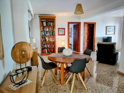 een woonkamer met een houten tafel en stoelen bij Apartamento Bella Vista in Salobreña