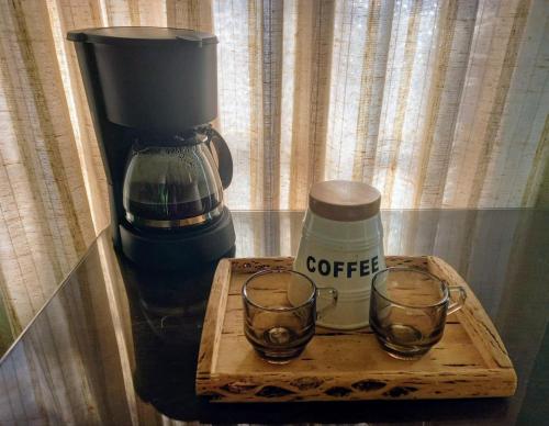 a coffee maker and two glasses on a table at Hospedaje in Salta