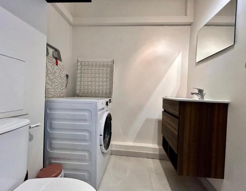 une salle de bain avec une machine à laver et un lavabo dans l'établissement Les Restanques 3 étoiles 4 à 5 pers 2143, à Grimaud