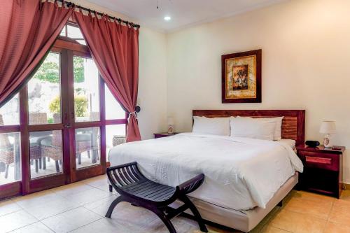 a bedroom with a bed and a chair and a window at La Paloma Blanca B1 in Jacó