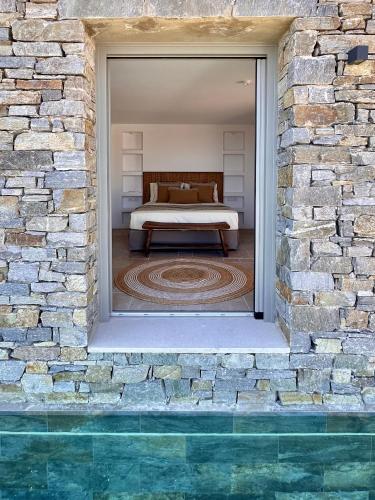 a bedroom with a bed in a brick wall at Egeo Paros in Kampos Paros
