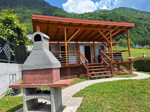 a small building with a wooden roof and a stove at Apartments Denis in Tolmin