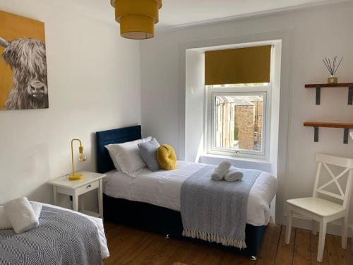 a bedroom with two beds and a window at Number 6 Crossgate in Fife
