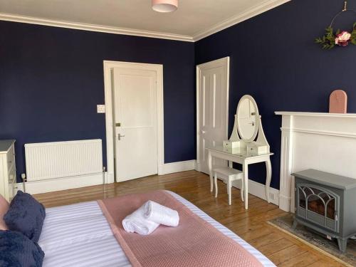 a blue room with a bed and a mirror at Number 6 Crossgate in Fife