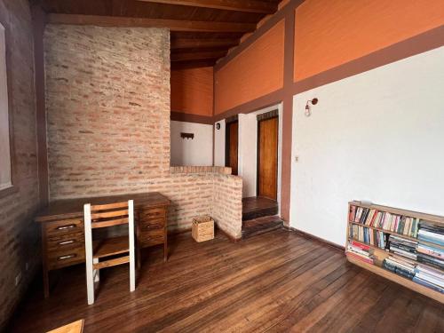 a room with a table and a chair and a brick wall at Habitación en chalet, Cipolletti in Cipolletti
