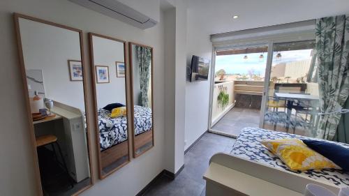 Cette chambre comprend un miroir, un lit et un balcon. dans l'établissement CapNat 340 Pas Seulement Desire, au Cap d'Agde