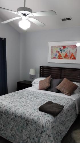 a bedroom with a bed with a ceiling fan at la casa de Carmen in Charlotte