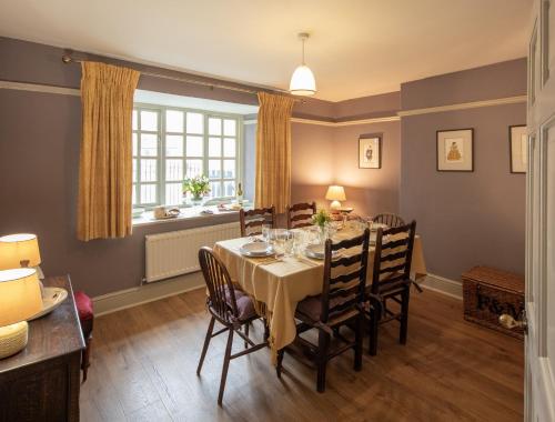 ein Esszimmer mit Tisch und Stühlen und einem Fenster in der Unterkunft Lightfoot Cottage in Bishop Auckland