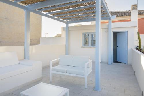 eine Terrasse mit einem weißen Stuhl und einer Pergola in der Unterkunft Luxury Houses La Mar de Bonita in Guardamar del Segura