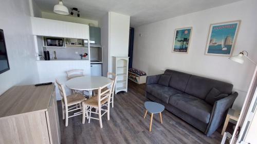 un salon avec un canapé et une table dans l'établissement Bel appartement avec parking, face à la mer, à La Rochelle