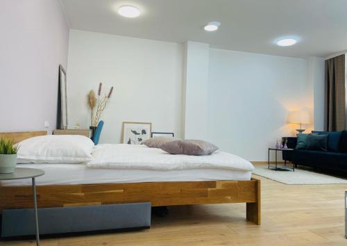 a bedroom with a bed and a living room at SALON des Fleurs Linz-Landstrasse in Linz