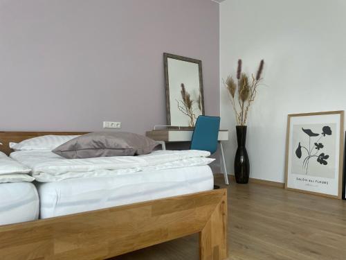 a bedroom with a bed and a table and a mirror at SALON des Fleurs Linz-Landstrasse in Linz