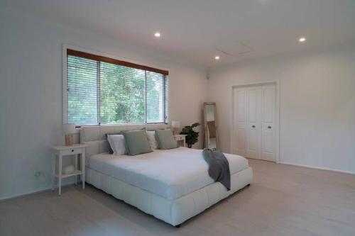 een witte slaapkamer met een groot bed en een raam bij Yasar farm stay Marshall view 