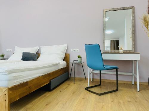 a bedroom with a bed and a blue chair at SALON des Fleurs Linz-Landstrasse in Linz
