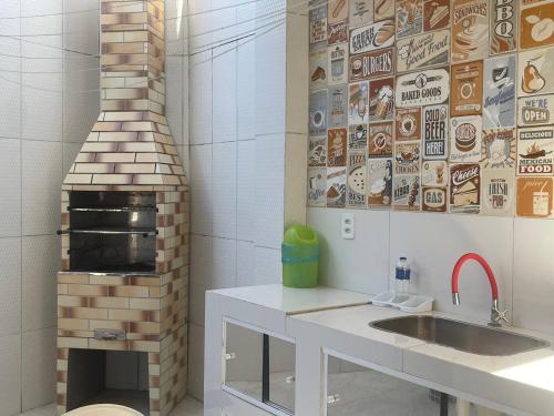 a kitchen with a sink and a brick oven at Praia de Ipitanga in Lauro de Freitas