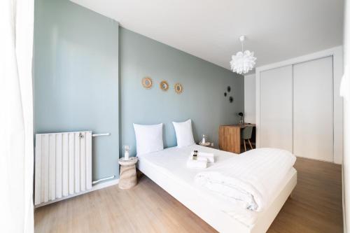 um quarto com uma cama branca e um radiador em Appartement rénové Proche Paris - 5 min transport em Montrouge