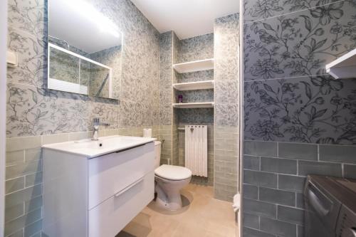 uma casa de banho com um lavatório branco e um WC. em Appartement rénové Proche Paris - 5 min transport em Montrouge