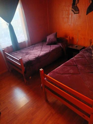 1 dormitorio con 2 camas y ventana en Cabaña el ricky en Cabrero