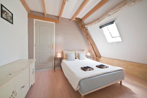 1 dormitorio con cama blanca y ventana en Centre equestre du passe temps, en Dégagnac
