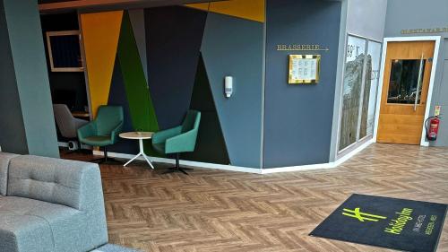 a lobby with a couch and chairs in a building at Holiday Inn Aberdeen West by IHG in Westhill 