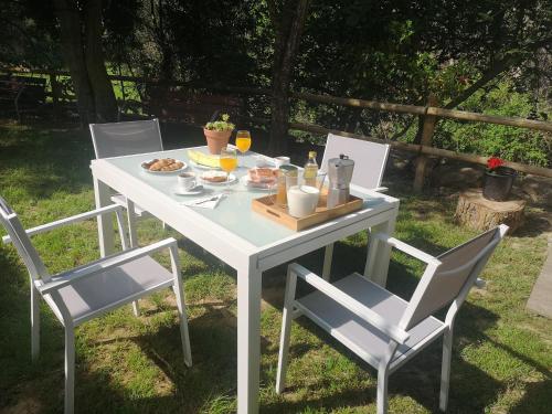 une table et des chaises blanches avec de la nourriture dans l'établissement Casa rural Ardetxal a 16km de Logroño y Laguardia, à Viñaspre