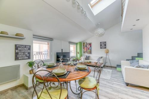 a dining room and living room with a table and chairs at Voiron House 2 Chambres Climatisation in Voiron