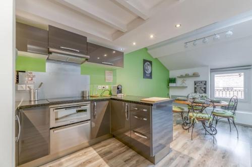 a kitchen with green walls and stainless steel appliances at Voiron House 2 Chambres Climatisation in Voiron