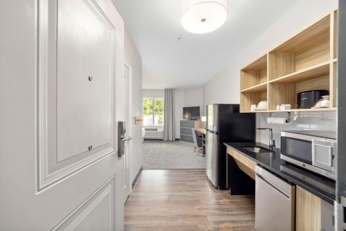 a kitchen with white cabinets and a refrigerator at Candlewood Suites - Ocala I-75 by IHG in Ocala