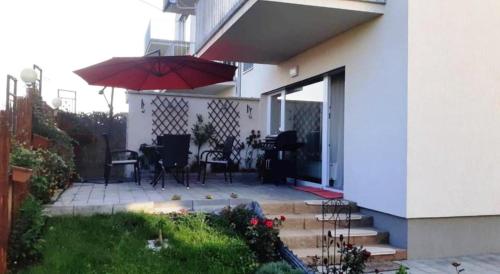 een huis met een patio met een tafel en een parasol bij VDK Apartament Swiss Village in Sibiu