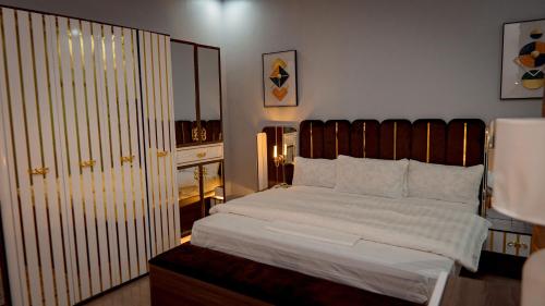a bedroom with a large bed with a wooden headboard at Mboka Village in Kahama