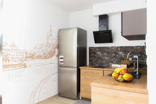 una cucina con frigorifero e cesto di frutta di Strumienna Apartament a Cracovia