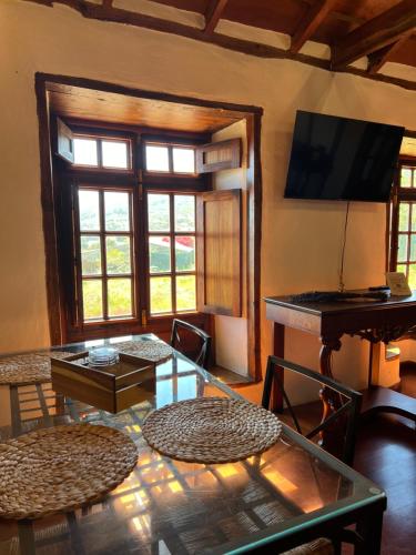 ein Wohnzimmer mit einem Glastisch und einem Klavier in der Unterkunft La Paredita Casa Taoro in Tanque
