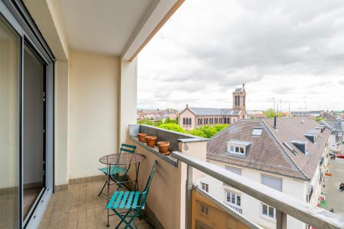 un balcon avec des chaises et une vue sur la ville dans l'établissement Le Saint Aloïse - Balcon, Vue à 10min du Centre, à Strasbourg