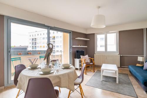 un salon avec une table, des chaises et un canapé dans l'établissement Le Saint Aloïse - Balcon, Vue à 10min du Centre, à Strasbourg