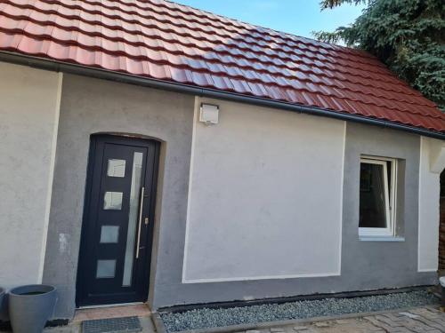 uma pequena casa com uma porta preta e um telhado vermelho em Elias Ruheoase em Pfungstadt