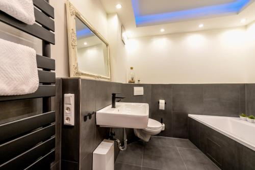 a bathroom with a sink and a toilet and a tub at Eigene Sauna 2 Schlafzimmer sehr zentral WinterbergHome in Winterberg