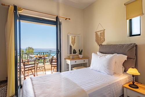 a bedroom with a bed and a balcony with a view at Terra Calma Residence in Karistos