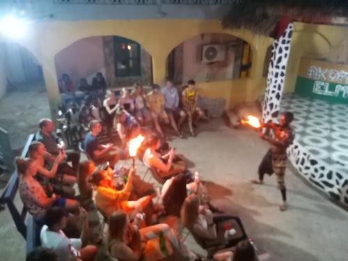 un grupo de personas sentadas alrededor de un escenario con antorchas en Akomapa Village, en Elmina