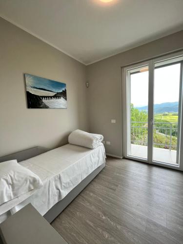 1 dormitorio con cama y ventana grande en Casa di campagna Colle Pertecone Locazione Turistica, en Spoleto